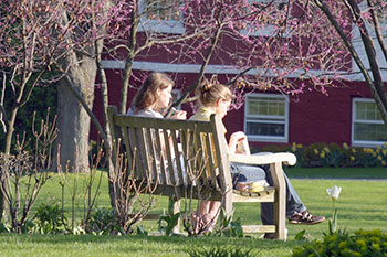 Two students sitting on a bench. Links to Gifts That Pay You Income